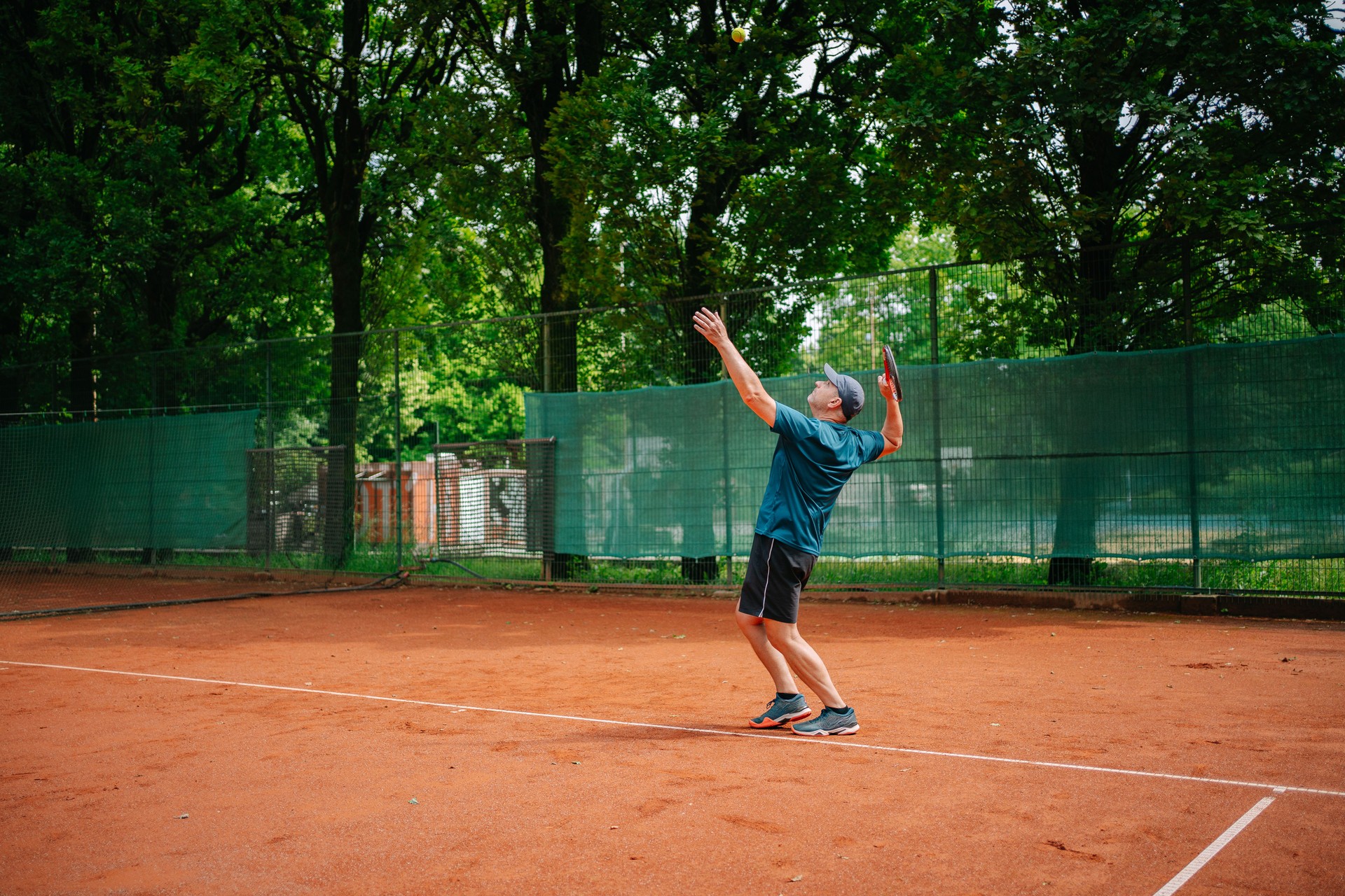 Mature man playing tennis in public park