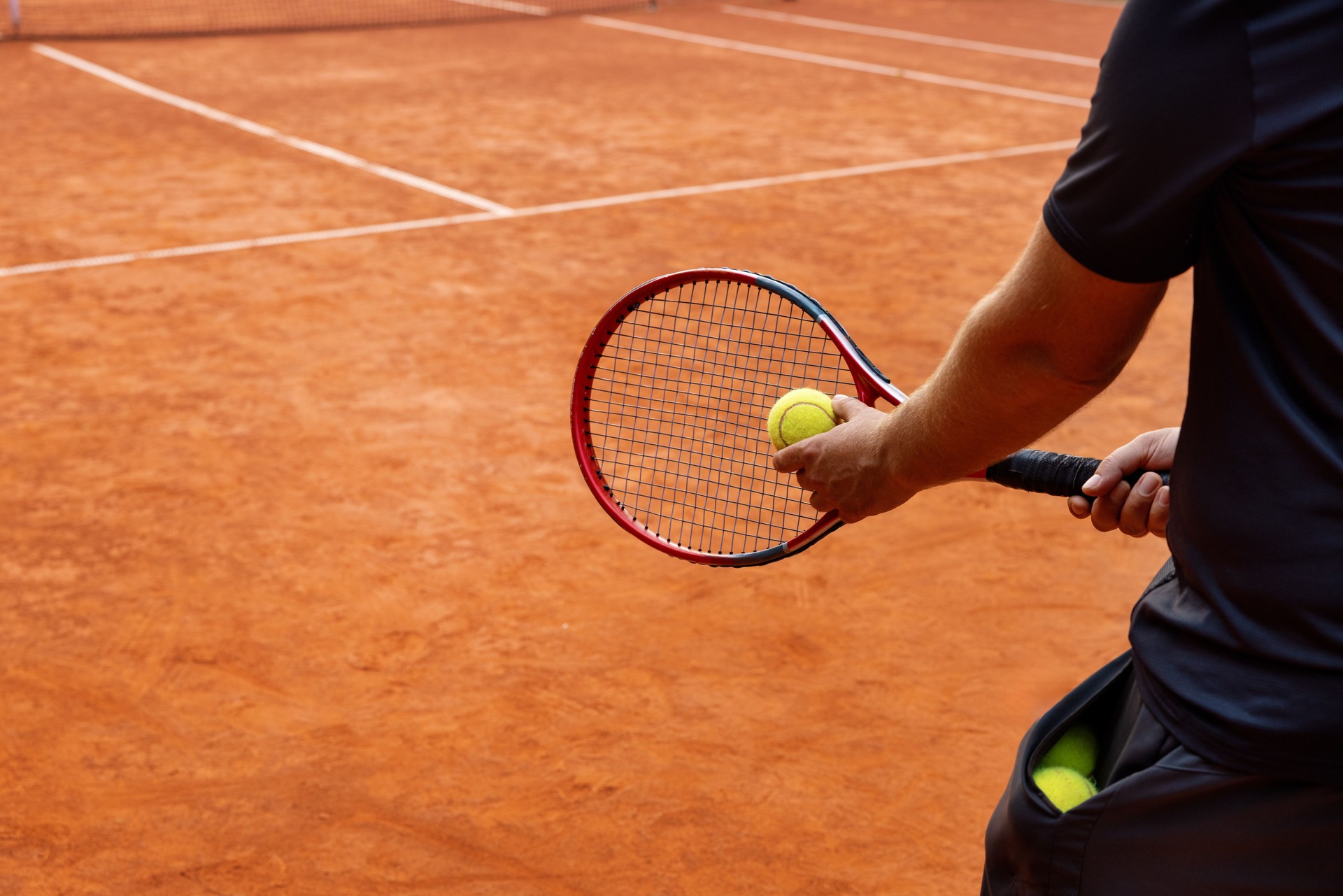 tennis player on outdoor clay court ready to serve the ball. copy space