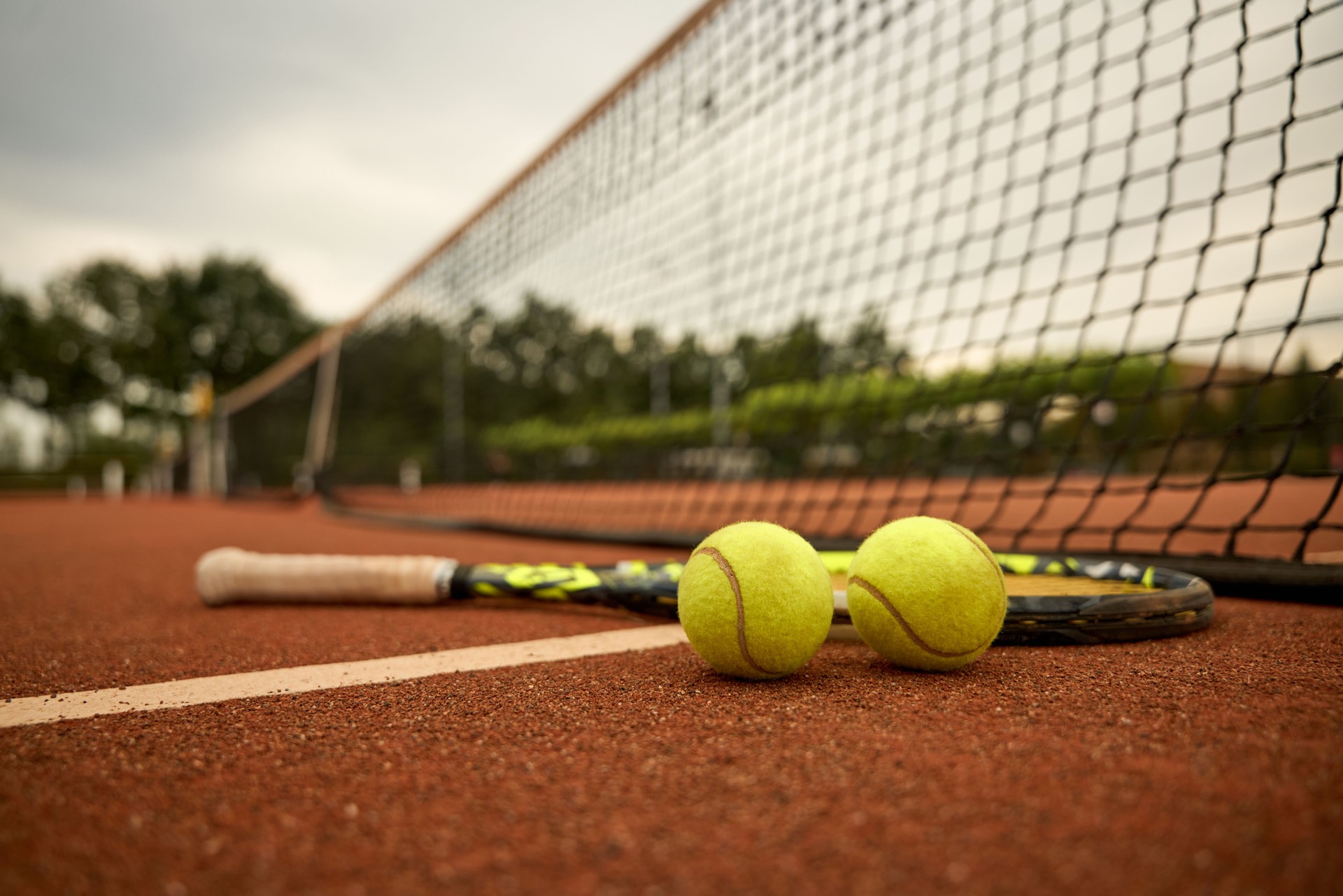 Tennis racket and two ball on a outdoor court